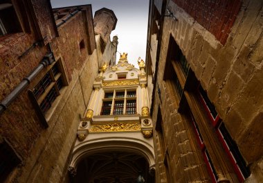 Bruges, Flanders Belçika. Ağustos 2019. Köprünün karşısındaki Piazza Burg 'e doğru ilerlerken, bu değerli manzarayı göreceksiniz: iki tuğla binayı muhteşem dekoratif bir pencereyle birleştirmek..