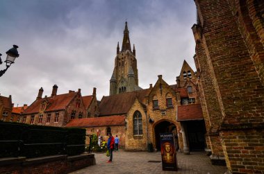 Bruges, Flanders Belçika. Ağustos 2019. Tarihi merkeze yaklaşan ortaçağ görünümü ortaya çıkıyor: kaldırımlı sokaklar, düşük kırmızı tuğlalı evler.
