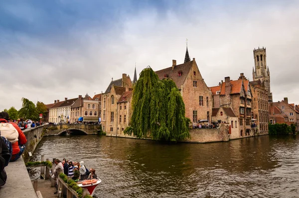 Bruges, Flanders Belçika. Ağustos 2019. Rozenhoedkaai, turistler tarafından en çok sevilen tarihi merkezin bir simgesidir: Söğüt ağacı ve çan kulesi ile evin etrafında kıvrılan kanal..
