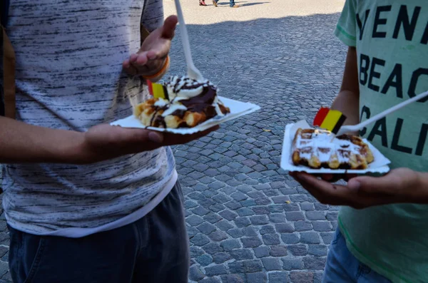 比利时佛兰德地区布鲁日2019年8月两个白人男孩挡住了城里的街道甜点 这是一个用奶油和巧克力装饰的令人开胃的华夫饼 — 图库照片