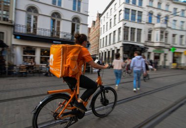 Gent, Belçika, Ağustos 2019. Take away.com 'dan bir işçi, yiyecek ve içecek dağıtım şirketi. Onları fark etmek kolay: tipik beyaz logolu gösterişli turuncu seyahat çantası.
