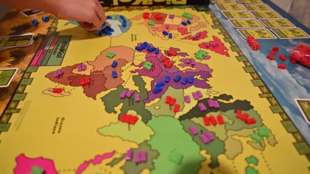 Torino, Piemonte, Italia. Marzo 2020. Incoronavirus pandemico. Durante la quarantena giochi da tavolo di strategia: un gioco di Risiko è in corso. Le mani dei giocatori sono viste posizionare le pedine . — Video Stock