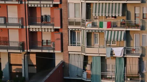 トリノ、ピエモンテ、イタリア。2020年3月。コロナウイルスのパンデミック。家のファサードには虹の絵とシートを掛け、「すべてがうまくいく". — ストック動画