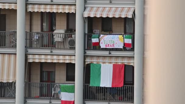 Turín, Piamonte, Italia. Marzo 2020. pandemia de Coronavirus. En las fachadas de las casas cuelgan las sábanas con el dibujo del arco iris y el mensaje "todo estará bien ". — Vídeo de stock