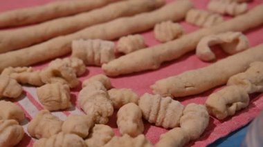 Ev yapımı patates köftesi. Hazır yapılmış gnocchi 'ye odaklanmış yakın plan görüntüsü ve daha işlenmemiş makarna sosisleri..