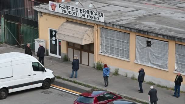 Turin, Piedmont, Italy. March 2020. Coronavirus, people wear masks to protect themselves from infection. Entrance to a bakery: people are lined up, spaced, waiting to take their turn. — Stock Video