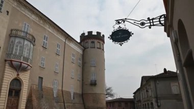 Costigliole d 'Asti, Piedmont, İtalya. Mart 2020. Kırmızı bitişli kulelerden birinde ve kale girişinde hareket olan bir kamera görüntüsü. Birkaç araba park etmiş..