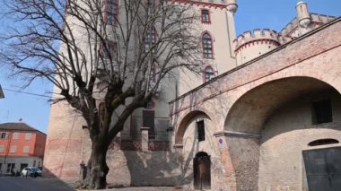 Costigliole d 'Asti, Piedmont, İtalya. Mart 2020. Köyün hemen dışında, yaprakları olmayan ağaçların arasında kırmızı yapraklarla süslenmiş zarif bir kale var..