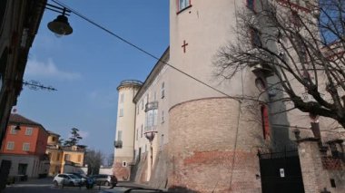 Costigliole d 'Asti, Piedmont, İtalya. Mart 2020. Kırmızı süslemeli zarif şatonun eğik görüntüleri. Büyük ve yüksek kule siperlerle çevrili..