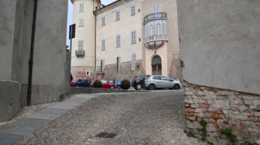 Costigliole d 'Asti, Piedmont, İtalya. Mart 2020. Kale girişinde eğik hareketli görüntüler. Yan taraftaki iki ev. Birkaç araba park etmiş..