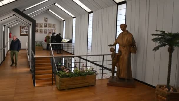 Colle Don Bosco, Piemonte, Italië. maart 2020. Het heiligdom gebouwd in het oude huis van de heilige. Vintage foto 's opgehangen aan de muur met bijschriften, rechts een houten standbeeld. — Stockvideo