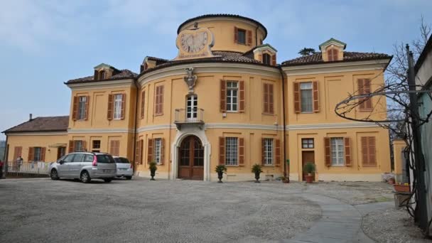 Costigliole d 'Asti, Πεδεμόντιο, Ιταλία. Μάρτιος 2020. Πλάνα με κλίση κίνηση στον πρώην αχυρώνα και το κάστρο σταθερό. Σήμερα είναι ένα άριστα διατηρημένο ιδιωτικό σπίτι με κίτρινη πρόσοψη.. — Αρχείο Βίντεο