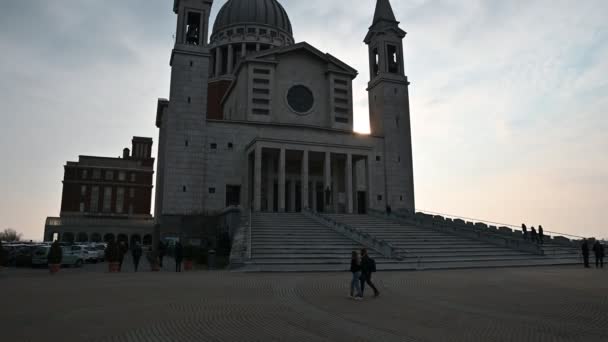 Colle Don Bosco, Piémont, Italie. Mars 2020. Vue sur l'imposante basilique. Images du mouvement d'inclinaison. À la base de la basilique, les gens marchent. Lumière en fin d'après-midi . — Video