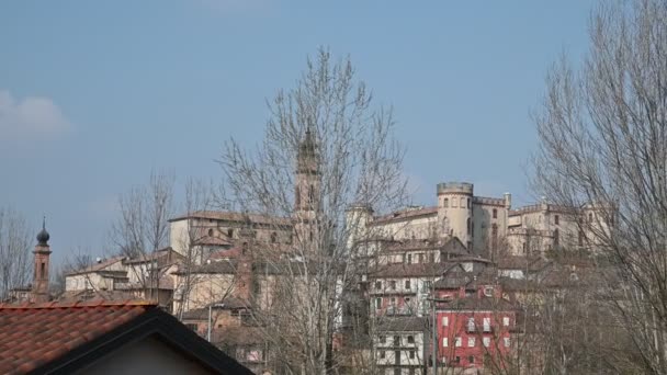 Costigliole d 'Asti, Piemonte, Italië. maart 2020. Pan beelden van het kasteel: zijn elegante en imposante vorm onderscheidt zich van de omliggende huizen. Blauwe lucht — Stockvideo