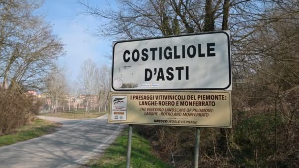 Costigliole d 'Asti, Piedmont, İtalya. Mart 2020. Köyün girişinde yol tabelası var. Turizm bilgileri: Langhe Roero ve Monferrato 'nun şarap yetiştiren manzaraları UNESCO' nun Dünya Mirası Alanlarıdır — Stok video