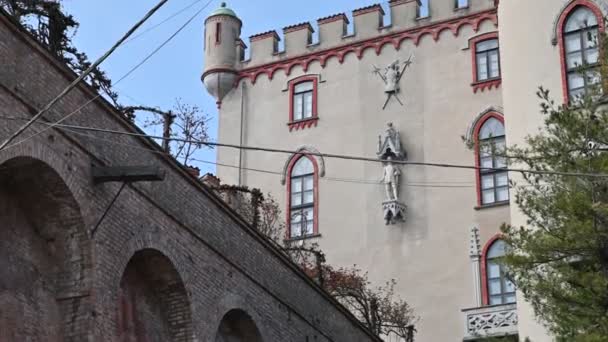 Costigliole d 'Asti, Piemont, Itálie. březen 2020. Nádherný boční pohled na hrad, všimněte si elegantní červené povrchové úpravy, která dává eleganci panství tělo. Na levé straně je malá rozhledna. — Stock video