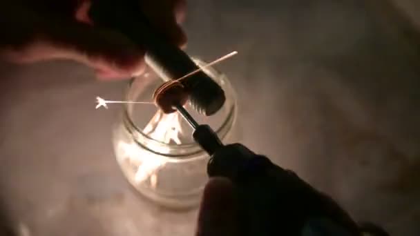 Footage where a small grinding wheel is notching a large bolt held up by the hands of a Caucasian male. Sparks and filings are collected in a glass jar: they create particular light effects. — Stock Video