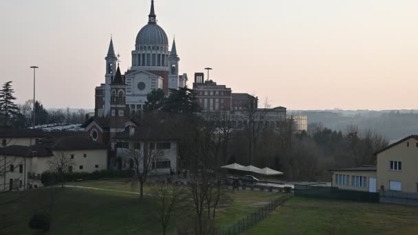 Colle Don Bosco, Piémont, Italie. Mars 2020. Vue sur l'imposante basilique. Images de mouvement incliné. Au pied de la basilique se trouve la maison où vivait le saint. Lumière de fin d'après-midi . — Video