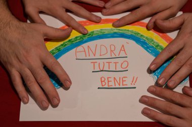 Torino, Piedmont, İtalya. Mart 2020. Cornonavirus karantinası. Beyaz çarşaftaki yakın plan görüntüde beyaz bir adam ve çocukların elleri gökkuşağı ile bir resim çerçeveler ve mesaj iyi olacaktır.!