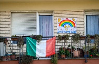 Torino, Piedmont, İtalya. Nisan 2020. Coronavirus. Gökkuşağının çarşafları evlerin ön cephesinde asılı. İtalya 'da 