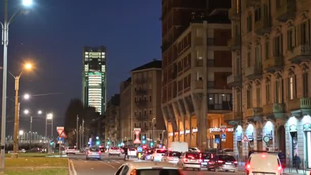 Turim, Itália, Piemonte. Fevereiro de 2020. Imagens nocturnas tiradas da Piazza Stauto. No fundo, o arranha-céu, sede do banco Intesa-SanPaolo. Luzes a piscar. Tráfego automóvel . — Vídeo de Stock