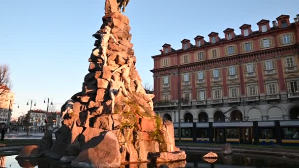 Turin, Piemonte-regionen. Italien, januari 2020. Piazza statuto, vid Frejus tunnel fontänen, bilder med lutning rörelse. Det varma morgonljuset lyser upp de vita statyerna, ovanpå den mörka ängeln. — Stockvideo
