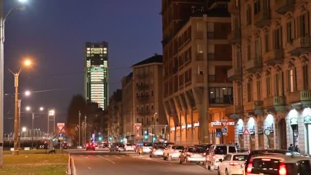 Turim, Itália, Piemonte. Fevereiro de 2020. Imagens nocturnas tiradas da Piazza Stauto. No fundo, o arranha-céu, sede do banco Intesa-SanPaolo. Luzes a piscar. Tráfego automóvel . — Vídeo de Stock