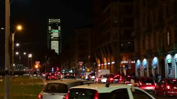 トリノ、イタリア、ピエモンテ。2020年2月。広場の自動販売機から撮影された夜の映像。背景には、 Intesa-SanPaolo銀行の本社である超高層ビル。点滅するライト。交通量. — ストック動画