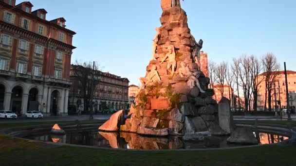 Torino, regione Piemonte. Italia, gennaio 2020. Piazza Statua, alla fontana del tunnel Frejus, riprese con movimento inclinato. La calda luce del mattino illumina le statue bianche, sopra l'angelo oscuro . — Video Stock