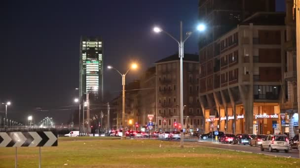 トリノ、イタリア、ピエモンテ。2020年2月。広場の自動販売機から撮影された夜の映像。背景には、 Intesa-SanPaolo銀行の本社である超高層ビル。点滅するライト。交通量. — ストック動画