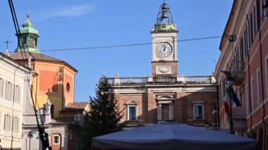 Ravenna, İtalya - 2019 Aralık 'ında Piazza del Popolo' daki saat kulesinde hareketli gündüz görüntüleri. Sağ tarafta İtalyan bayrağı..