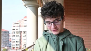 Torino, İtalya - Şubat 2020: Kahverengi saçlı ve kıvırcık saçlı beyaz bir çocuk koruyucu maskesini göstermek için kollarını açıyor.