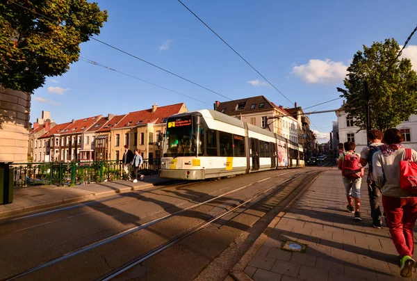 Gent, Belçika, Ağustos 2019. Şehre hizmet eden tramvaylar sessizce ve verimli bir şekilde çalışır. Şehir kanallarından birinin üzerinden bir tramvay geçiyor, öğleden sonra ışığı altında, insanlar kaldırımda..