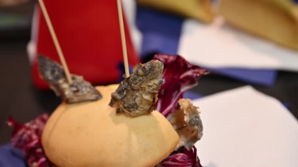 ウナギのサンドイッチに焦点を当ててクローズアップ画像 イタリアのComacchio の特産品 サンドイッチはラディッキオの葉とカルピオーネの皮で詰められています 2本の棒は尾とパンの頭をスティック — ストック動画