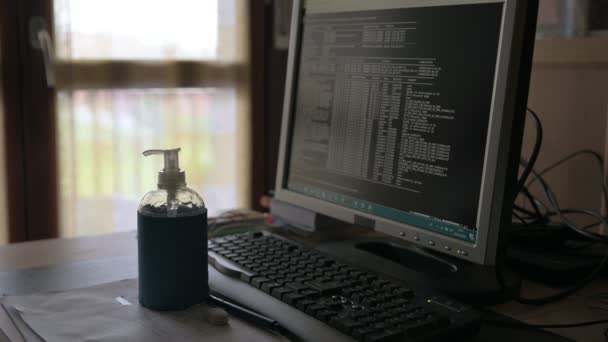 職場のテーブルで消毒ジェルを使って自宅でコンピューターやコロナウイルスや仕事をしている男性のビデオです — ストック動画