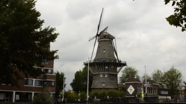Amsterdam, Hollanda - Ağustos 2019: Eski ve modern birlikte yaşayan bir yel değirmeni. İçeride bir bira fabrikası var..