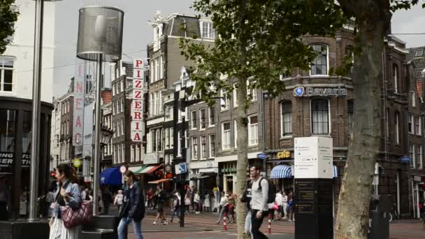アムステルダム オランダ 2019 人々は道路の交差点を渡ります 背景にはレストランのピザの書き込み — ストック動画