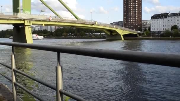 德国法兰克福 2019年8月 连接主广场大楼和其他河岸的主要绿色桥梁 蓝天白云缓慢移动 一艘驳船从下面经过 — 图库视频影像