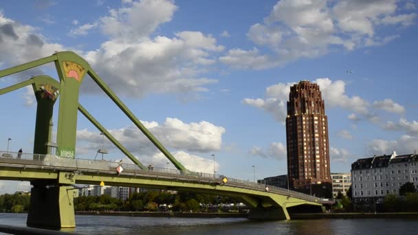 ドイツのフランクフルト 2019 メインプラザの建物と他の川の銀行を結ぶメインの緑の橋 青い空に白い雲の動きが遅い — ストック動画