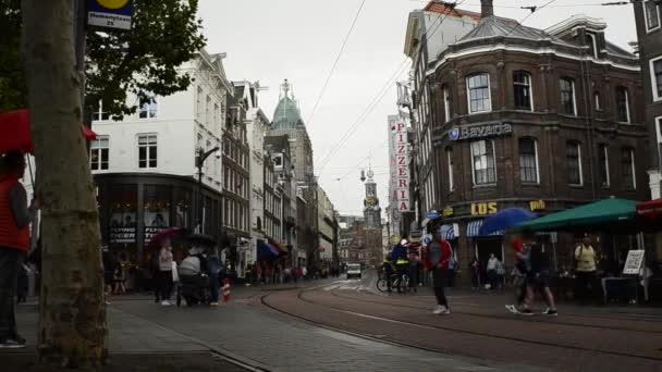 アムステルダム オランダ 2019 歴史的な中心部では雨が降っており いくつかの通行人には傘があります 背景には 街のランドマークの一つであるミントタワーが見えます — ストック動画