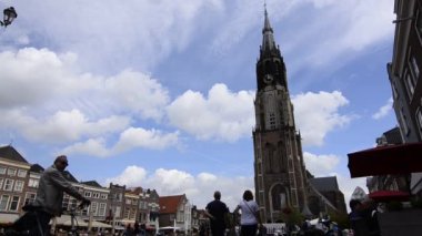 Delft, Hollanda - Ağustos 2019 eski kasaba meydanı, belediye binasına ve yeni kiliseye bakıyor. Sayısız kafe ve restoran, insanlar meydanda yürüyor. Sabit çerçeve.