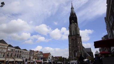 Delft, Hollanda - Ağustos 2019 eski kasaba meydanı, belediye binasına ve yeni kiliseye bakıyor. Sayısız kafe ve restoran, insanlar meydanda yürüyor. Sabit çerçeve.