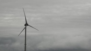 Hollanda, Kuzey Denizi - Ağustos 2019 Gri bir günde bir rüzgar türbini elektrik üretiyor. Aşağıdan yukarıya doğru hareket et.