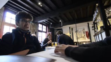 Bruges, Belçika - Ağustos 2019 tarihi ve büyüleyici La Garre bira fabrikasında, bira tatma. İki çocuk servis edilmeyi bekliyor, arka planda bir çift kupalarını masaya koymuşlar.. 