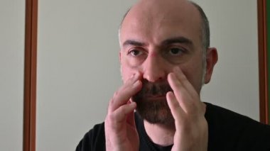 Koronavirüsten korunmak için koruyucu maske takan beyaz bir adamın portresi: maske çıkarıldığında, kenar ve elastik izler deride iz kalır..