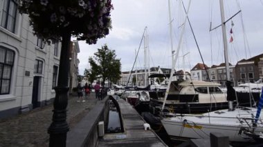 Goes, Hollanda - Ağustos 2019: küçük ve güzel limanın görüntüleri. İskele boyunca, evlerle dolu, turistler lüks demirli teknelere göz gezdiriyorlar..
