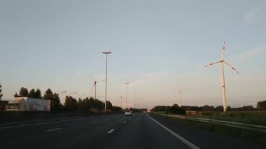 Zelanda, Hollanda - Ağustos 2019: Otoyolda giderken arabanın içinden bakış açısı. Rüzgar türbinleri yol boyunca koşar