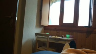 Dağ evindeki yataktan bakış açısı. Örtülerden çorapları çıkmış ayaklar. Pencereden içeri güçlü bir ışık giriyor