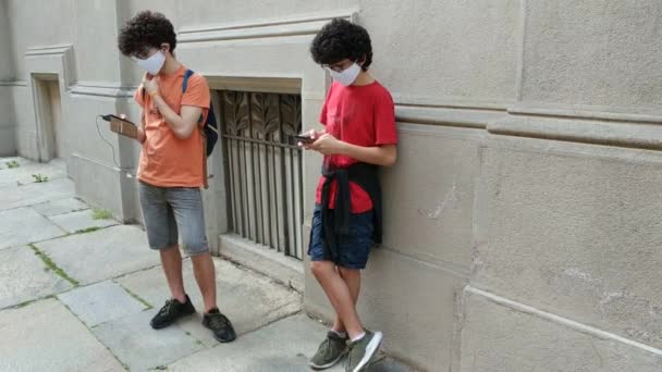 Two Caucasian Boys Protective Masks Using Smartphones Time Coronavirus — Stock Video