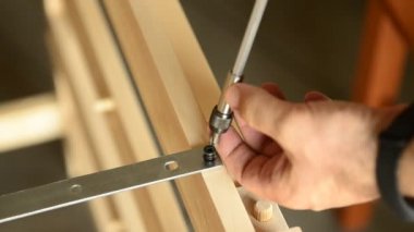 Tahtadaki elektrikli tornavidayla sabitlenmiş bir çift vidanın yakın plan çekimi..